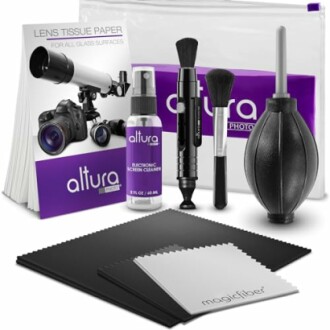 Camera cleaning kit with brushes, air blower, lens tissue, and cleaning solution.