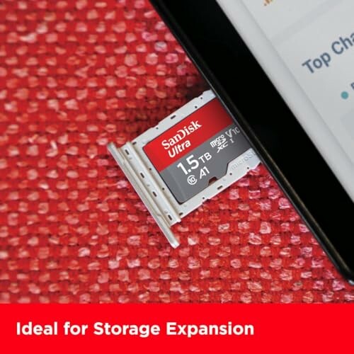 SanDisk Ultra 1.5TB microSD card next to a device on red surface.